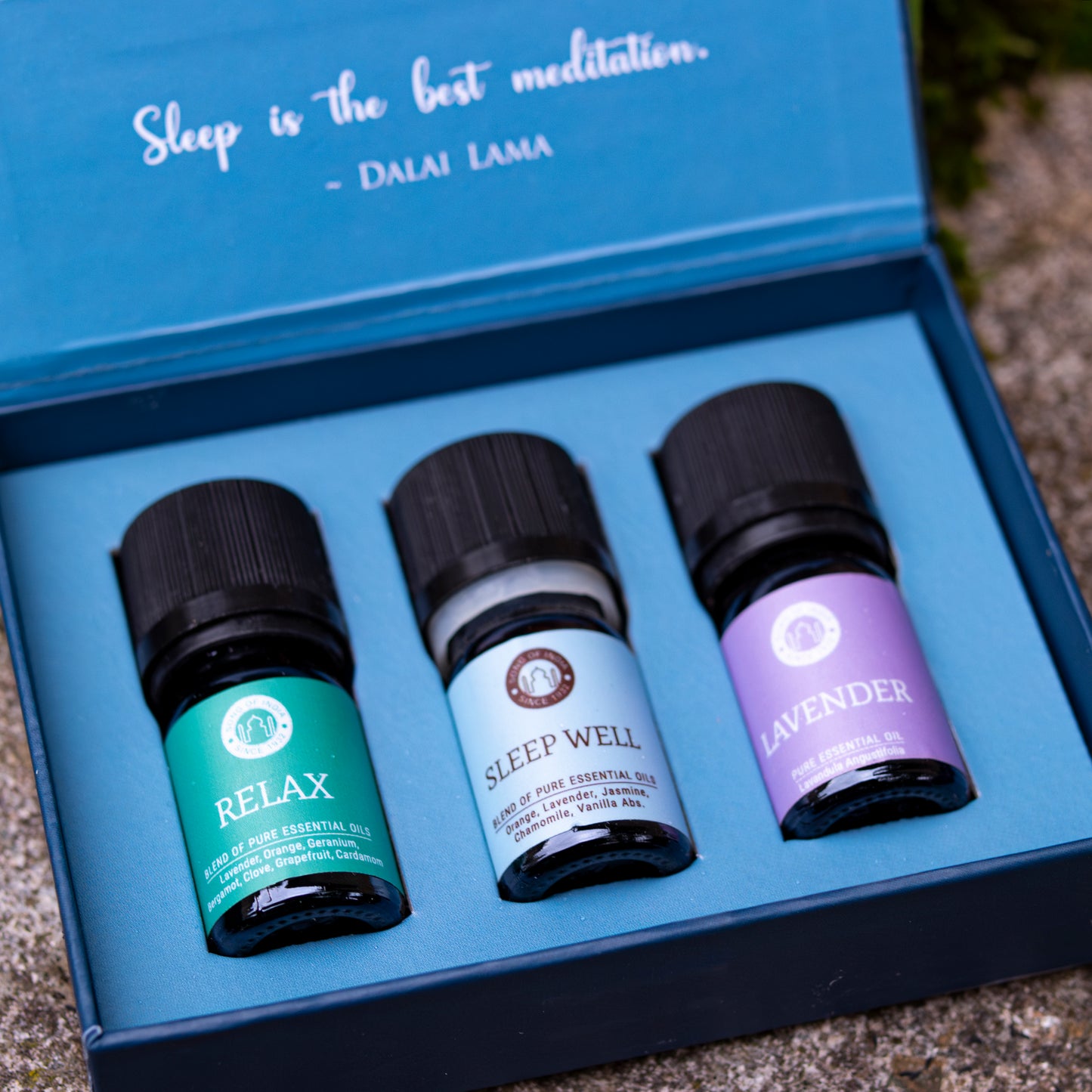 Geöffnete Verpackung des ‘Sleep’-Duftöl-Sets mit drei Fläschchen: ‘Relax’, ‘Sleep Well’ und ‘Lavender’, präsentiert auf blauem Hintergrund mit einem Zitat von Dalai Lama im Deckel.