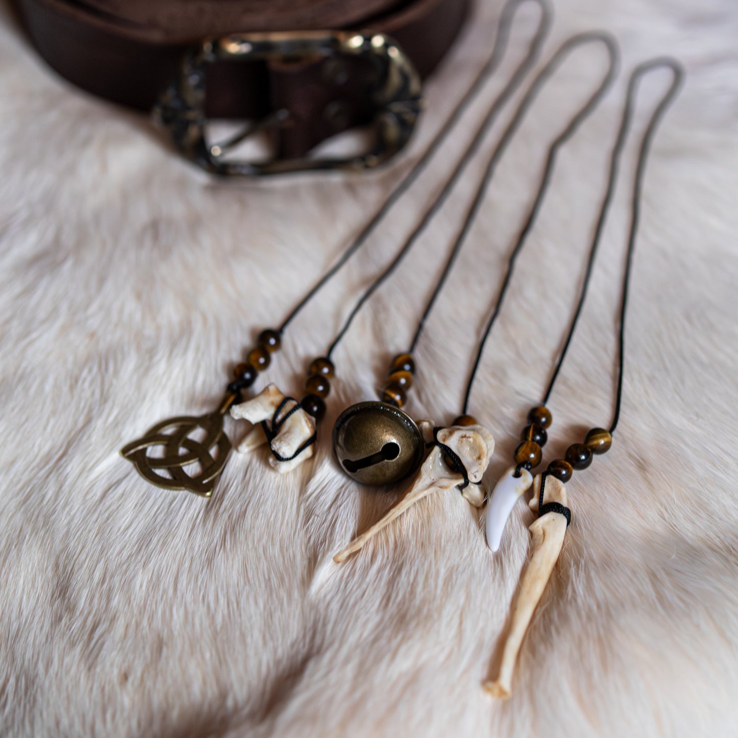 Handgefertigte Gürtelcharms mit Tigerauge, Knochen und keltischer Symbolik für Mut, Schutz und innere Stärke.